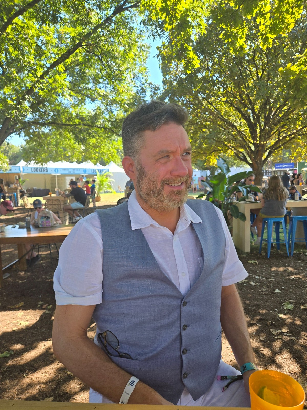 Me smiling outdoors in a blue vest
